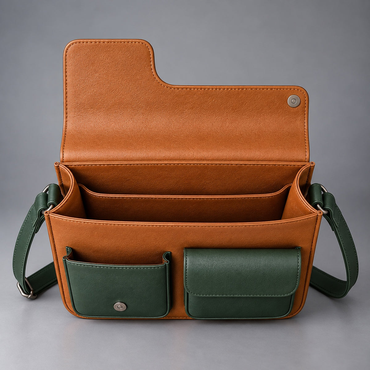 Open tan and green leather messenger bag showing roomy compartments and front pockets