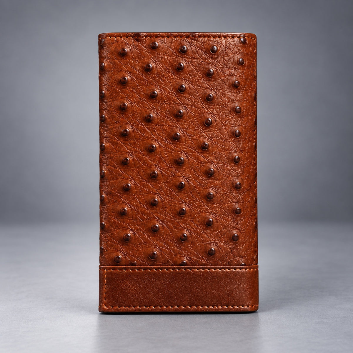 Brown ostrich leather travel wallet front view with raised quill texture and stitched lower panel