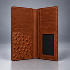 Open brown ostrich leather travel wallet showing card slots, note compartments and ID window