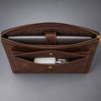 Open dark brown leather laptop portfolio with securing tab and front accessory pocket
